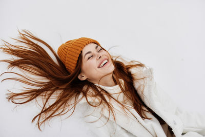 Portrait of beautiful young woman against white background