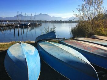 Boats moored in lake against sky