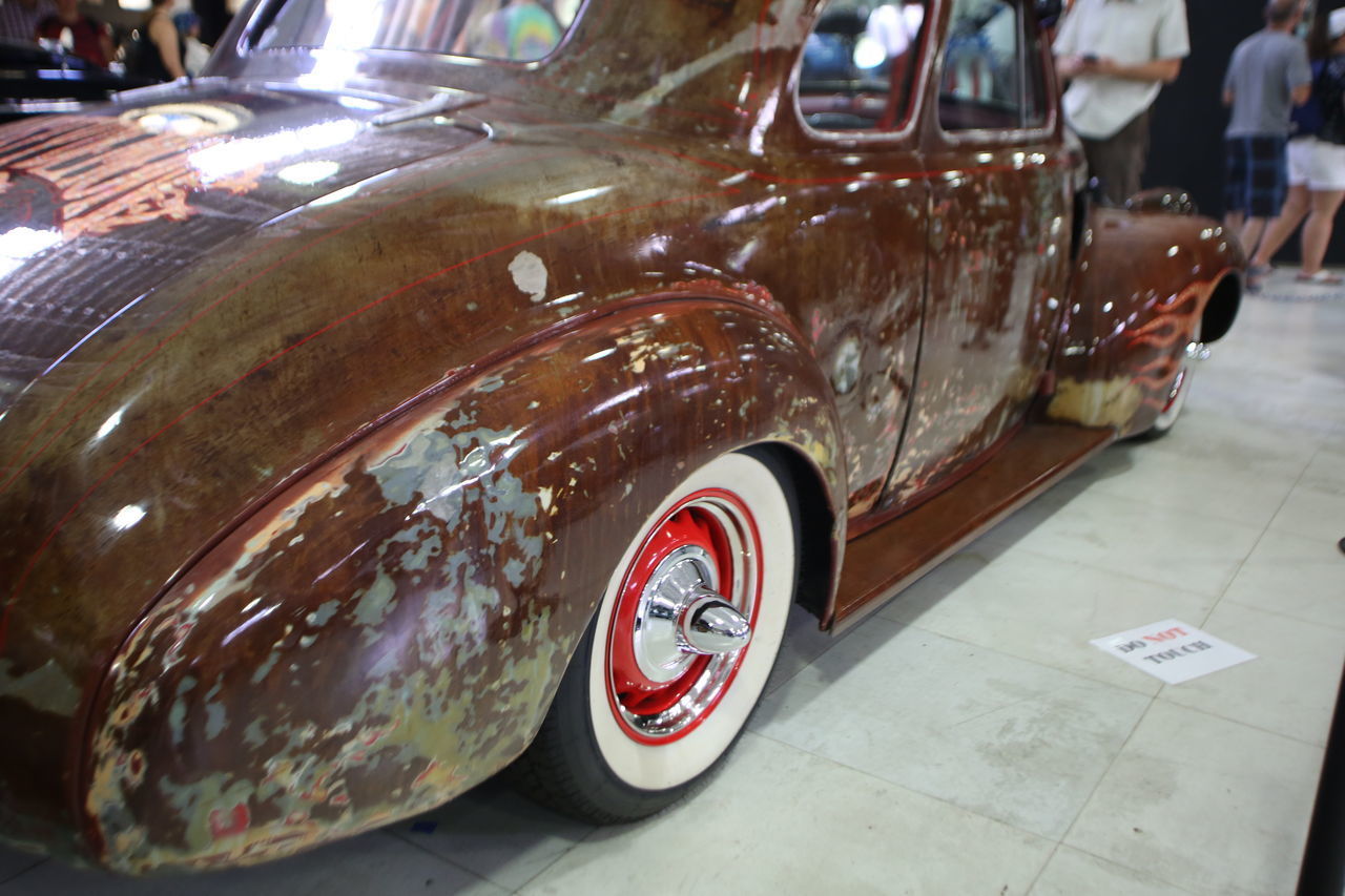 CLOSE-UP OF VINTAGE CAR WITH REFLECTION OF CARS ON MIRROR