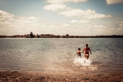 Men on beach against sky