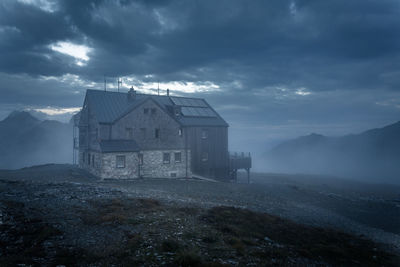 House on mountain against sky