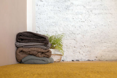 Stack of blankets and plant in corner