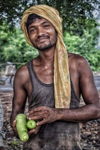 Portrait of shirtless man holding fruit