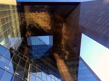 Low angle view of modern glass building against sky