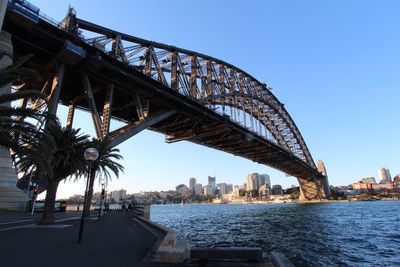 Bridge over river in city against sky