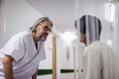 Doctor talking to patient in hospital corridor