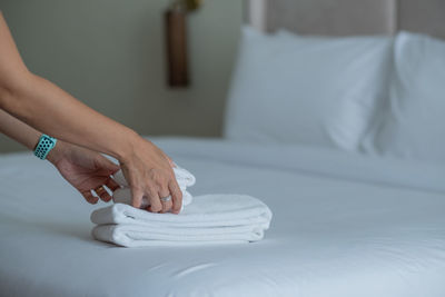 Low section of woman with baby on bed at home