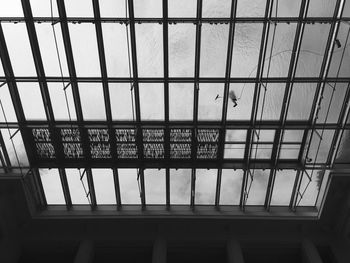 Low angle view of built structure against sky seen through window