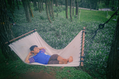 View of boy relaxing in hammock