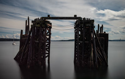 Wooden pier over sea against sky