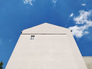 Low angle view of plain building against blue sky