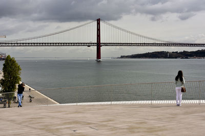 Rear view of people walking on suspension bridge