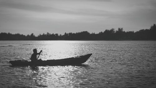 Man surfing in lake against sky