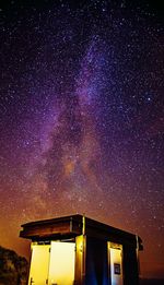 Low angle view of house against milky way at night