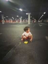 Full length of boy sitting in mirror at night