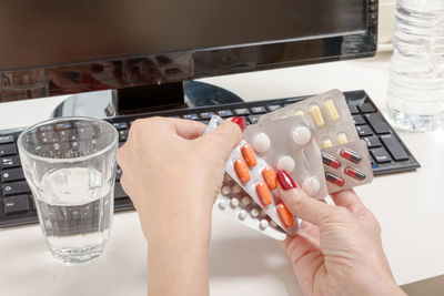 Midsection of woman holding drink on table