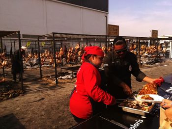 Man standing on barbecue grill against sky