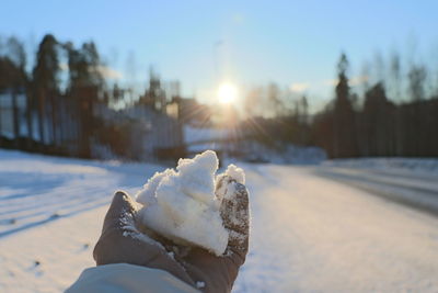 Person holding ice cream cone during winter