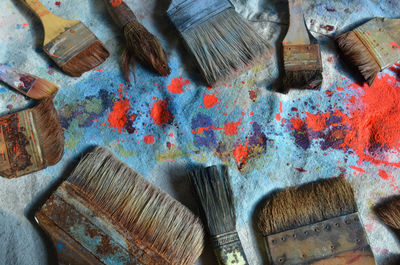 Much used paint brushes on paint-spattered canvas drop cloth