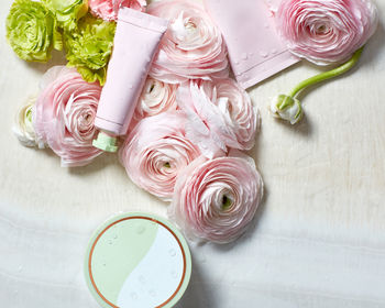 Skin cream and roses and moisture on textured surface