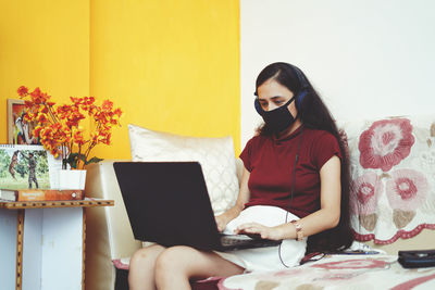 Young woman using mobile phone at home