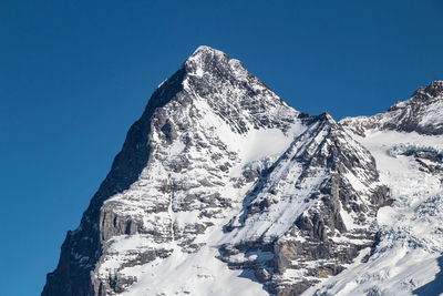 Scenic view of snowcapped mountains against clear blue sky