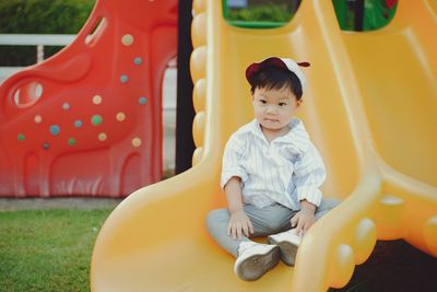 Portrait of boy sitting on slide