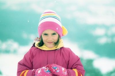 Portrait of smiling girl standing against sky