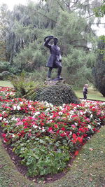 Low section of woman by flowers on field