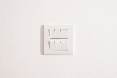 Close-up of telephone booth against white wall