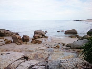 Rocks on beach against sky