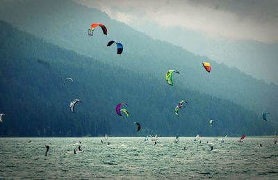 People paragliding over sea against sky