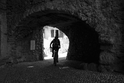 Rear view of man standing by wall in building