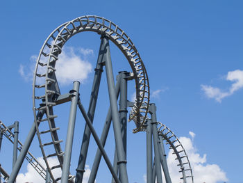 Low angle view of ferris wheel against blue sky