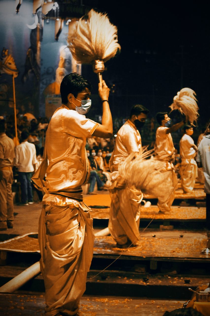 REAR VIEW OF PEOPLE DANCING AT NIGHTCLUB