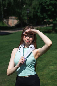 Young caucasian long-haired woman in sportswear is doing yoga in public park. outdoor workout.