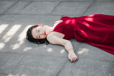 High angle portrait of woman lying down on floor