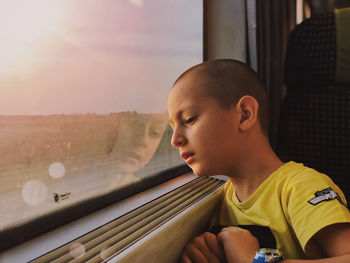 Portrait of boy looking through window