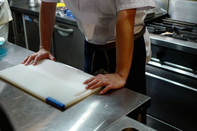 Midsection of chef standing in commercial kitchen