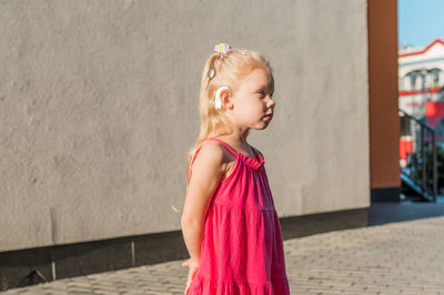 Portrait of girl standing on footpath