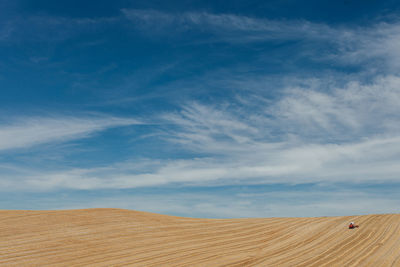 Scenic view of sand dune against sky