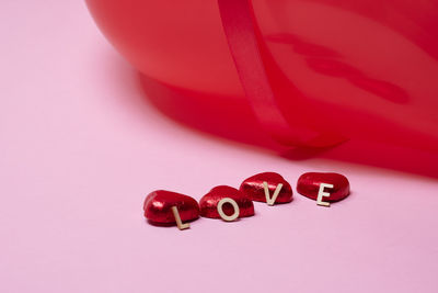 Heart-shaped candies on pink background