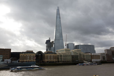 View of buildings in city against cloudy sky