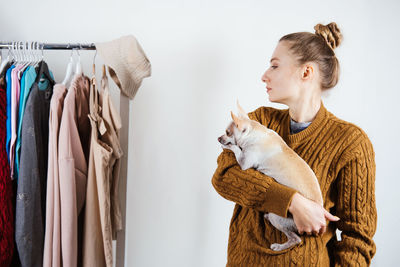 Beautiful woman with dog looking at garments