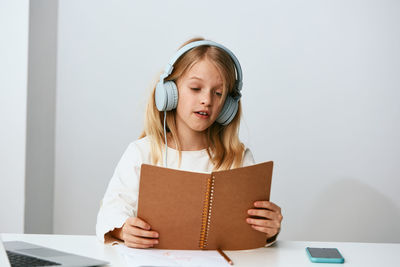 Portrait of young woman using digital tablet while sitting on table