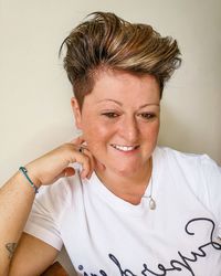 Portrait of smiling young woman against wall