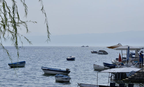 Boats moored on sea against clear sky