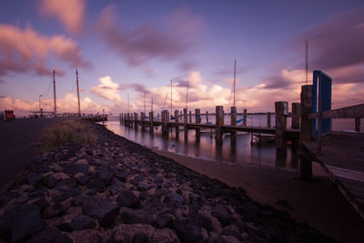 Pier over sea against sky during sunset