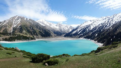 Scenic view of lake by mountains against sky