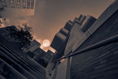 Modern cityscape against sky during sunset